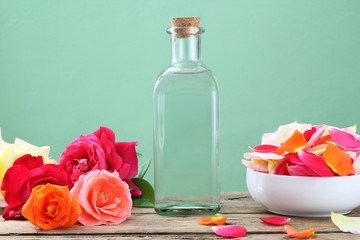 acqua di fiori con petali di rosa in bottiglia di vetro sfondo rustico