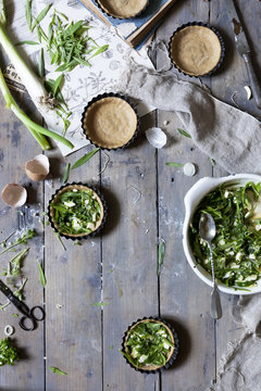 Preparation of little quiche with fresh ingredients on wooden rustic surface
