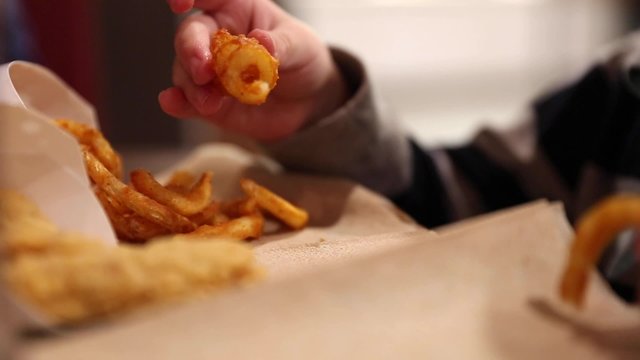 little boy eating curly fries