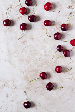 juicy whole fresh cherries from above on pink marble surface