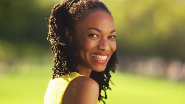 Cute black woman smiling in a park