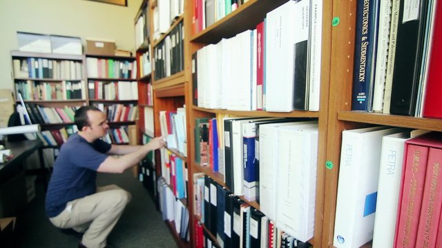 man looking through business library