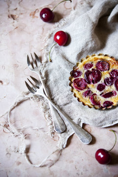 one little cherries clafoutis on table with two forks and cloth