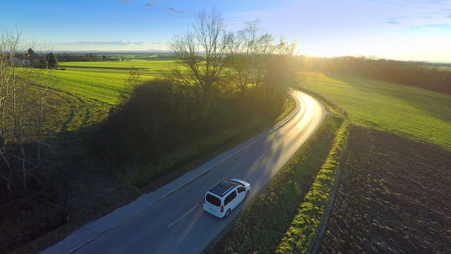 Aerial of vehicle driving towards the sunset