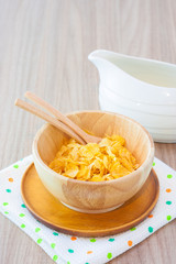 wooden bowl of nutritious and delicious corn flake cereal on wooden table