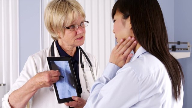 Senior doctor explaining neck x-ray to patient