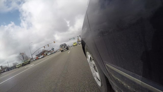 Exterior low shot of car driving to store in rain