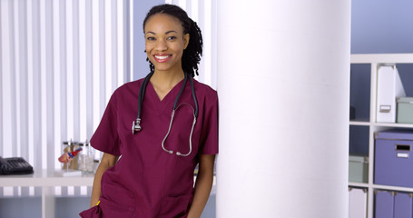 Black woman nurse smiling in office