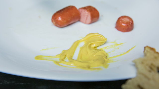 Soak hot-dog in mustard close up