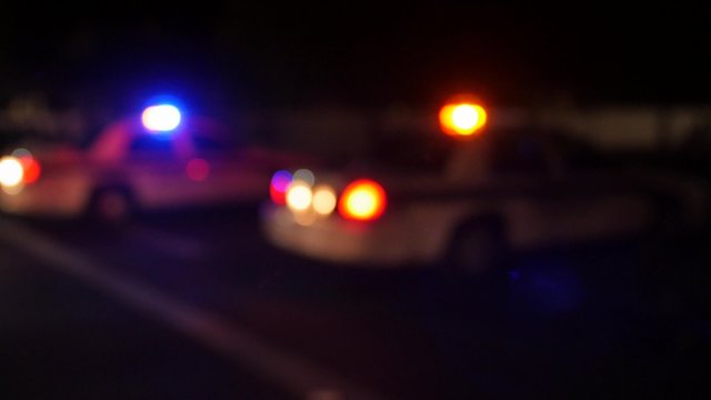 A police cars lights at an accident scene at night out of focus