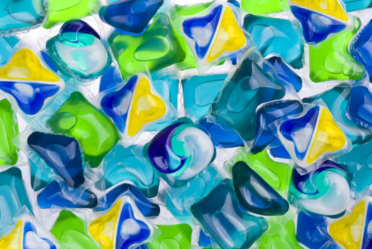 Background of various capsules with laundry detergent and dishwasher soap