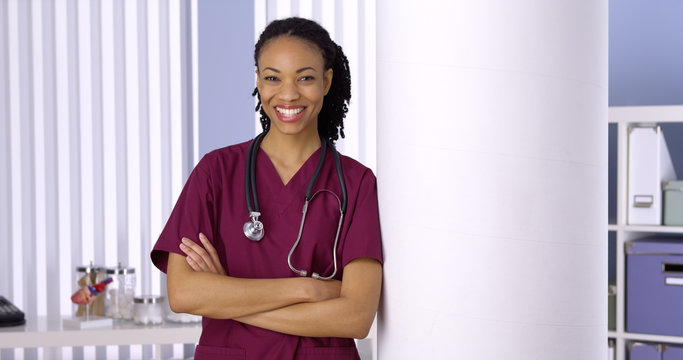 Confident black woman doctor smiling in office
