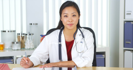 Chinese doctor talking to camera at desk