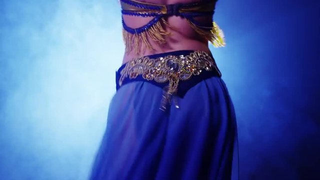 Rear view of young woman belly dancer dancing