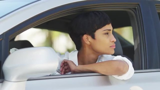 Black woman in car looking around out of window