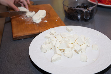 Plate with paneer cut into pieces and cutting board
