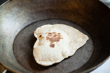 Puffed Indian bread puri on frying pan