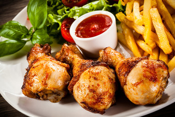 Grilled chicken legs with chips and vegetables 