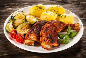Barbecued chicken leg with boiled potatoes and vegetables 
