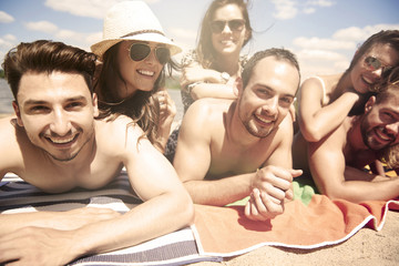 Group of friends sunbathing on the beach.