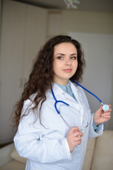 Portrait of young woman doctor on white coat standing in hospital