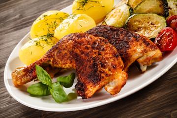 Barbecued chicken leg with boiled potatoes and vegetables 