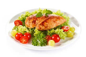 Roast chicken fillet and vegetables on white background