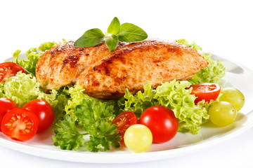 Roast chicken fillet and vegetables on white background