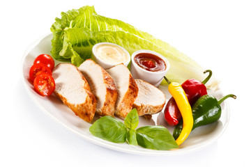 Roast chicken fillet and vegetables on white background 