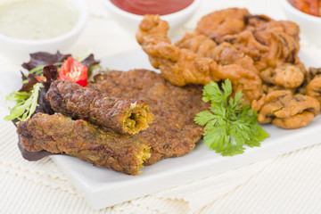 South Asian Starters - Selection of seekh and shami kebabs, mushroom and chicken pakoras and onion bhajjis. Served with salad, mint raita, lime pickled and chilli sauce.
