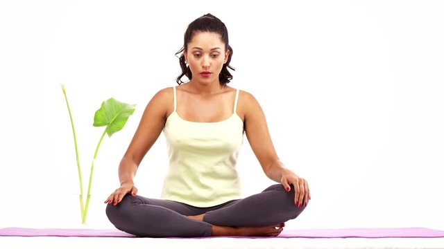 Beautiful Latina meditating on yoga matt