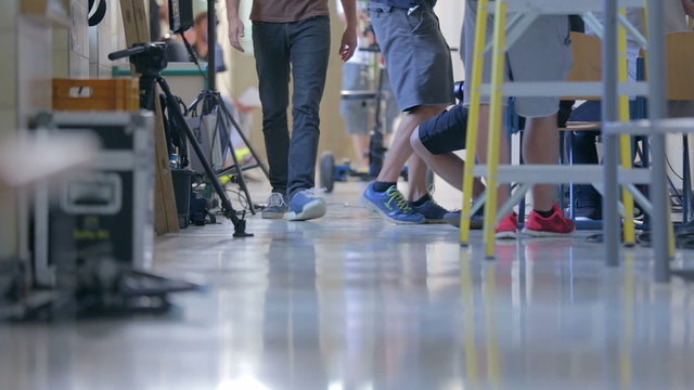 Movie crew on set close up on legs on hall