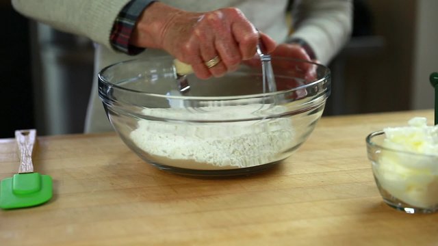 a woman cutting a pie crust dough