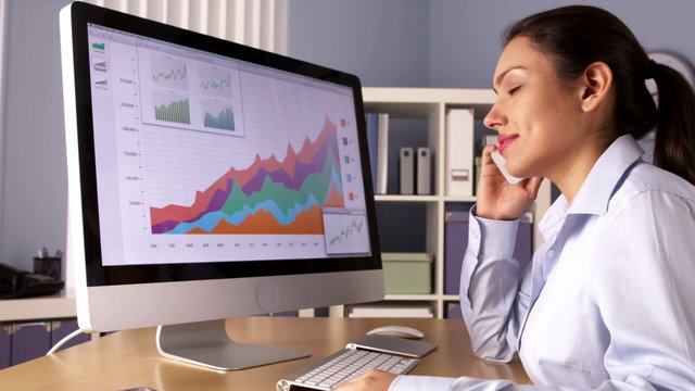 Mexican businesswoman talking on phone and working in office