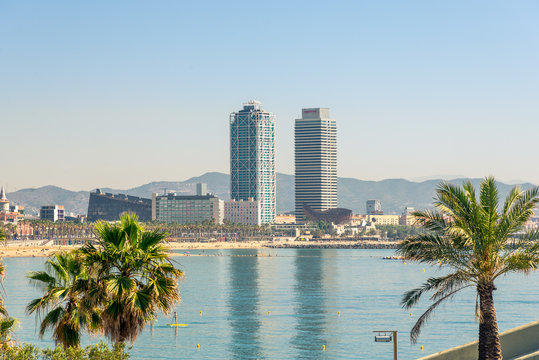 View from Barceloneta to Port Olimpic in Barcelona. The port is characteristic for its both high rises directly by the sea. The Hotel Arts and Torre Mapfre