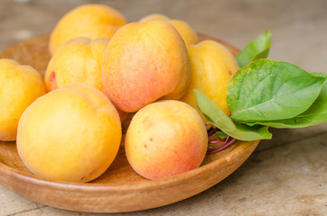 Wooden bowl full of ripe apricots.