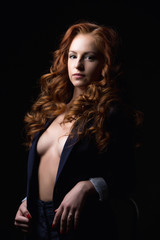 Fototapeta na wymiar Red-haired model posing in jacket on naked body