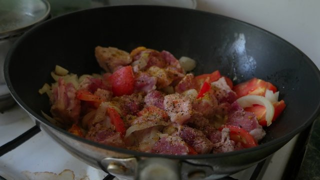 Pork meet and vegetables  in a wok pan. Mixing