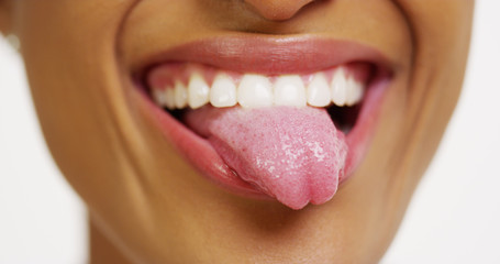 Close up of African woman with white teeth smiling and sticking tongue out