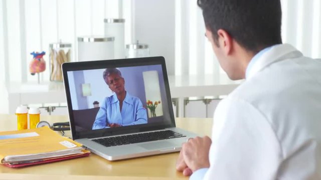 Mexican doctor video chatting with mature patient