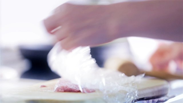 Marinating meat with protective plastic close up