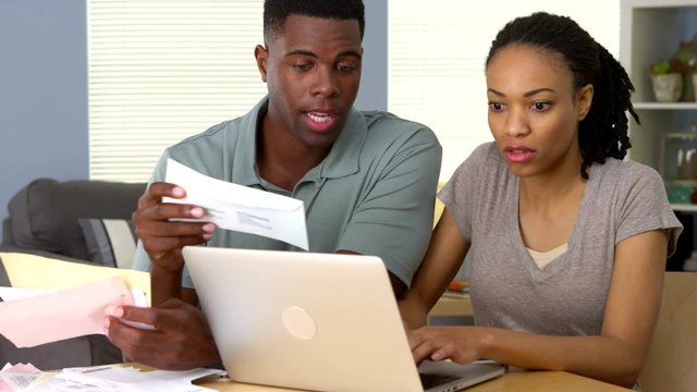 Young black couple working together to pay bills online