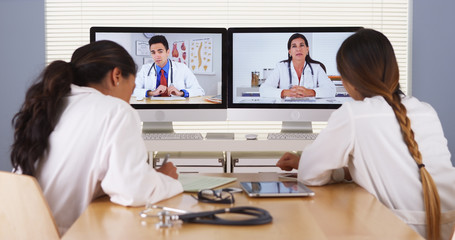 Fototapeta premium Mixed race team of medical doctors having a video conference
