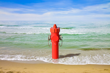 A hydrant at the seaside. Plenty of water: concept image