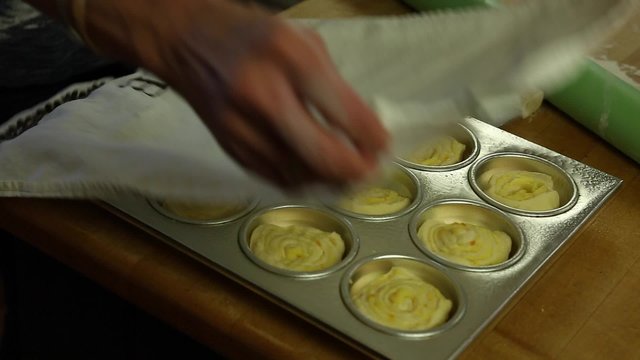 a woman lets orange rolls rise to bake