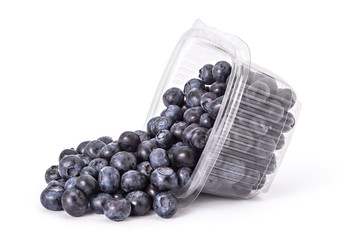 Box or punnet and spilled fresh ripe organic blueberries on a white background