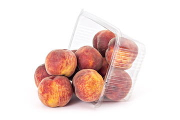 Box or punnet and spilled fresh ripe organic peaches isolated on white background © Simic Vojislav