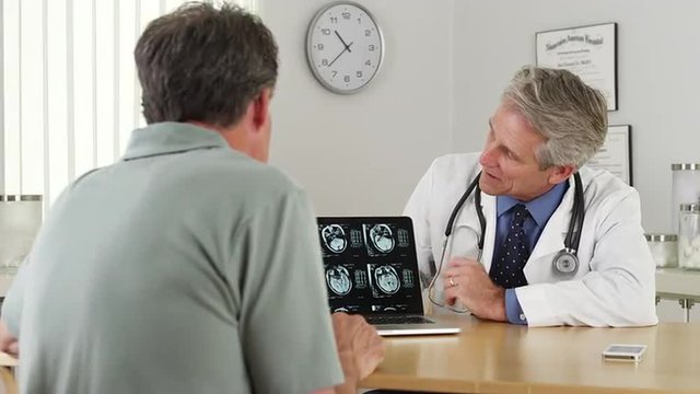 Senior doctor reviewing xrays with patient
