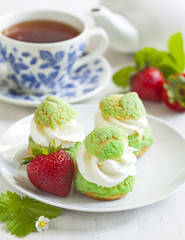 Profiteroles with strawberry compote and whipped cream.
