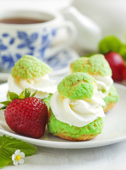 Profiteroles with strawberry compote and whipped cream.